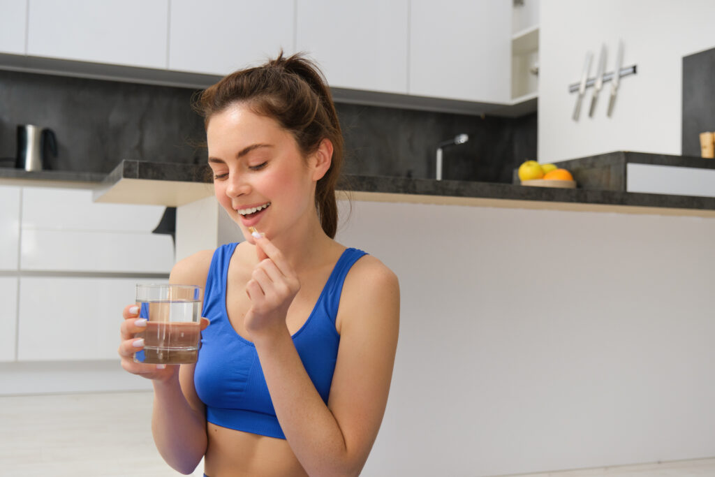 Mulher tomando suplemento, destacando os benefícios da teacrina para energia e foco.